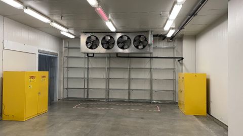 Inside of a loading bay with concrete floors and industrial fans