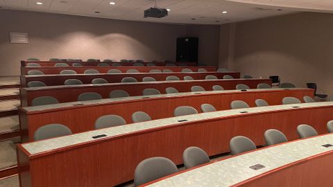 A lecture-style room with more than 7 rows of table space and chairs